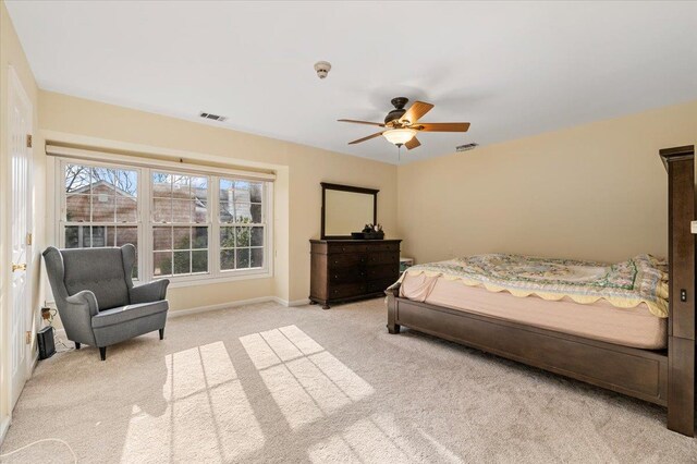 bedroom featuring light colored carpet, baseboards, visible vents, and a ceiling fan