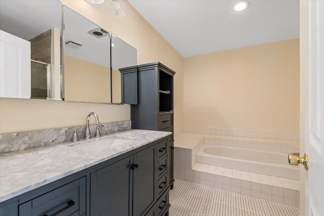 full bath with tile patterned flooring, a bath, tiled shower, and vanity