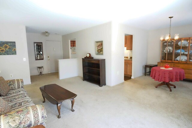 living room with light colored carpet and an inviting chandelier