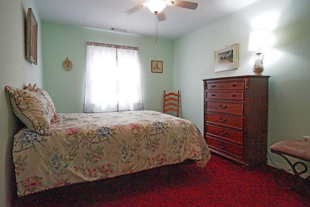 carpeted bedroom with a ceiling fan and visible vents