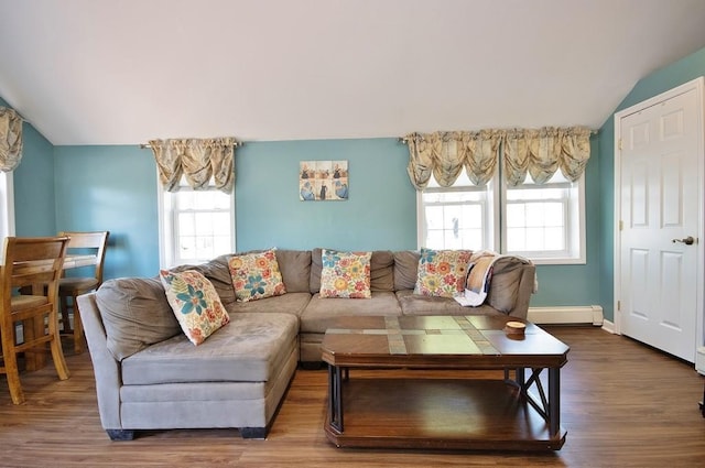 living room with a healthy amount of sunlight, baseboard heating, wood finished floors, and lofted ceiling