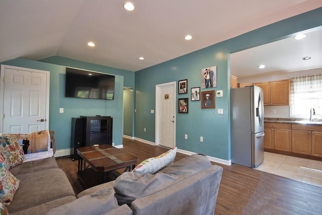 living area featuring light wood-style floors, baseboards, vaulted ceiling, and recessed lighting