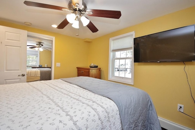 bedroom with a ceiling fan and baseboard heating