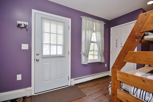 doorway with a baseboard heating unit and wood finished floors