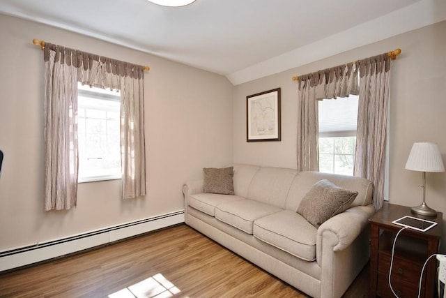 living area with wood finished floors, lofted ceiling, and a baseboard radiator