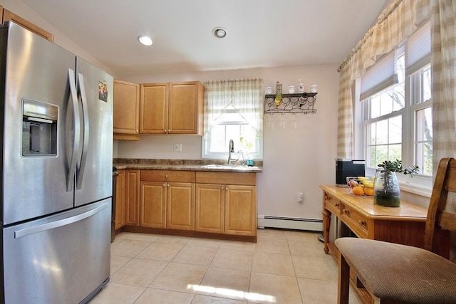 kitchen with a sink, stainless steel fridge with ice dispenser, baseboard heating, and a healthy amount of sunlight