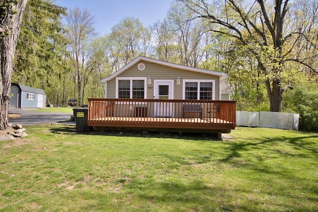 rear view of property with a yard, fence, and a wooden deck
