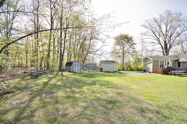view of yard with a storage shed, an outbuilding, and a deck