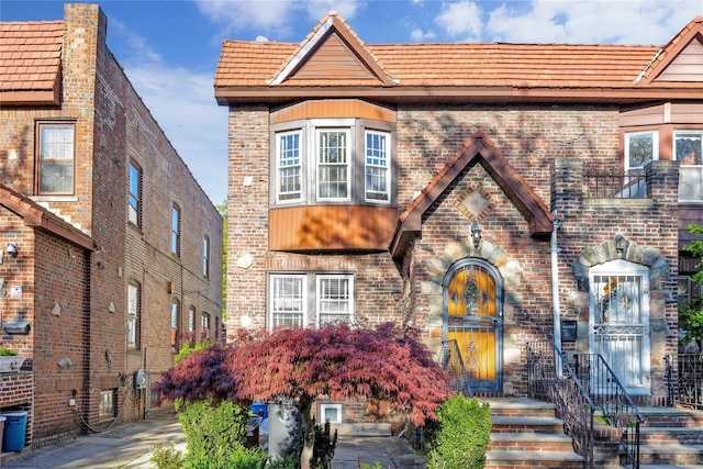 tudor house with a tiled roof and brick siding