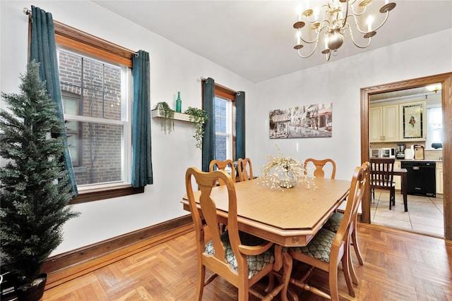dining area featuring an inviting chandelier and baseboards