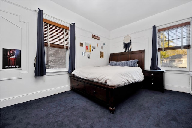 bedroom featuring baseboards and dark carpet