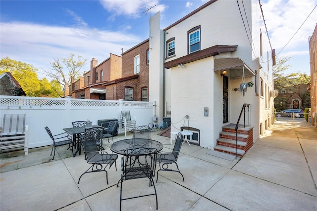 exterior space with fence, outdoor dining area, and a residential view