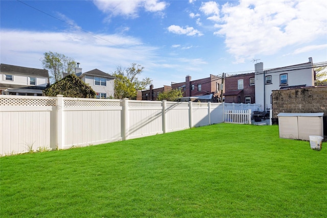 view of yard featuring a fenced backyard and a residential view