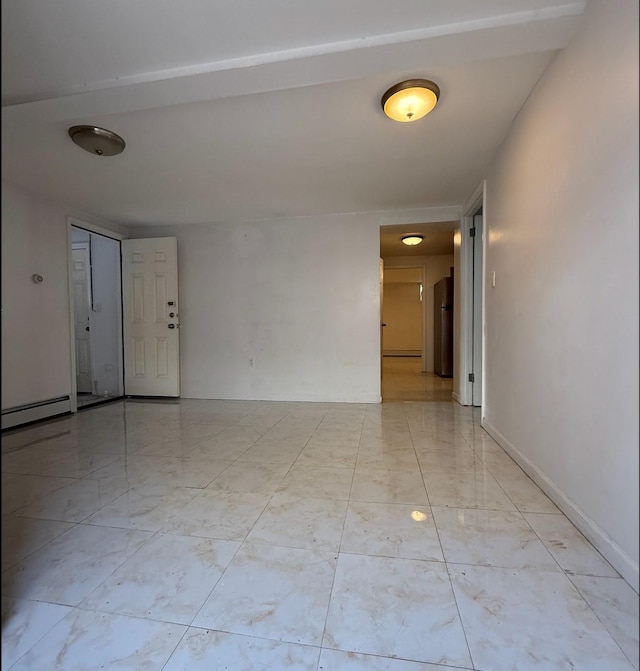 spare room with marble finish floor and a baseboard radiator