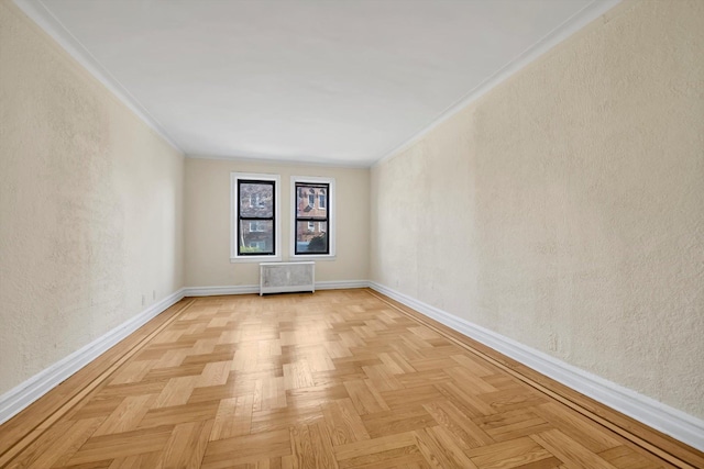spare room featuring crown molding, baseboards, a textured wall, and radiator heating unit