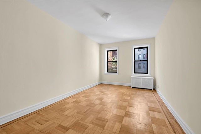 empty room featuring radiator heating unit and baseboards