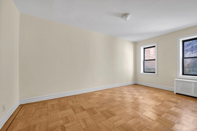 empty room featuring radiator and baseboards