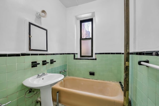 full bath with a bath, a wainscoted wall, and tile walls