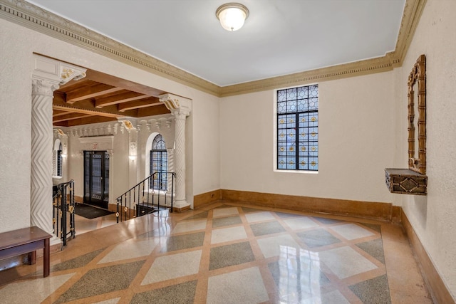 foyer entrance with crown molding, baseboards, a textured wall, and decorative columns