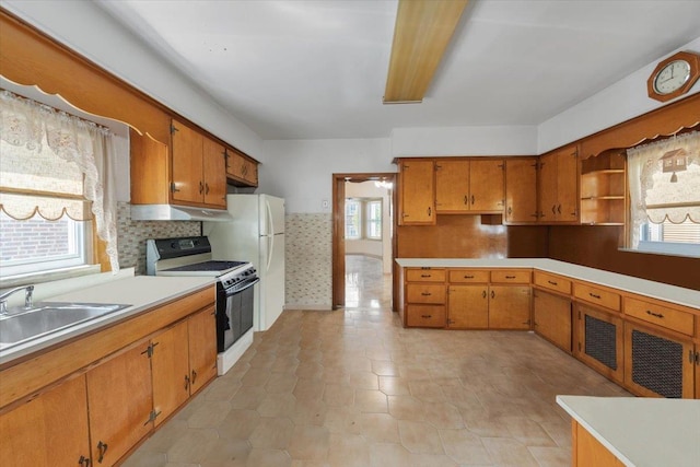 kitchen with light countertops, electric range oven, brown cabinets, and tasteful backsplash
