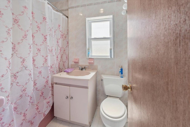 full bath featuring tile walls, toilet, vanity, curtained shower, and tile patterned floors