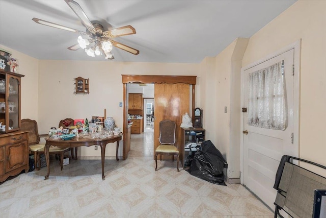 dining area featuring baseboards, light floors, and ceiling fan