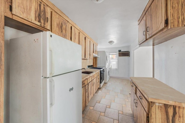 kitchen featuring a wall unit AC, stone tile flooring, brown cabinetry, white appliances, and light countertops