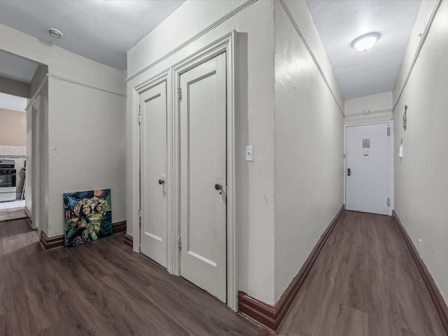 hall featuring baseboards and wood finished floors