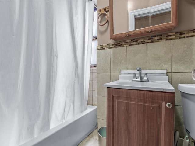 full bath with shower / bath combo with shower curtain, vanity, toilet, tile walls, and tile patterned floors