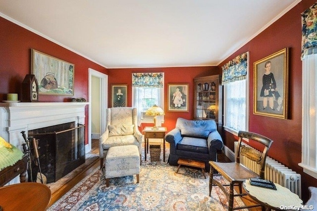 57020 Rte 25, Southold, NY 11971 - living area featuring crown molding, a fireplace with raised hearth, baseboards, and wood finished floors
