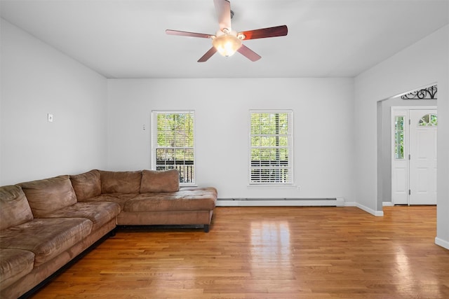 living room featuring baseboards, light wood finished floors, ceiling fan, and baseboard heating
