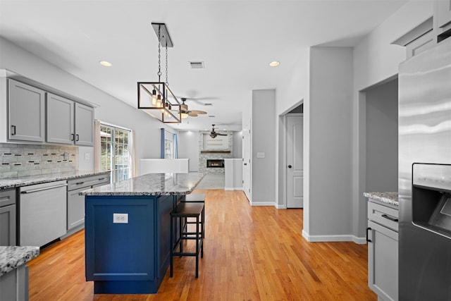 kitchen with visible vents, open floor plan, tasteful backsplash, appliances with stainless steel finishes, and gray cabinetry