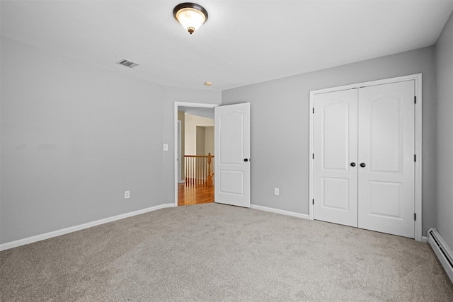 unfurnished bedroom featuring a closet, visible vents, baseboards, a baseboard heating unit, and carpet
