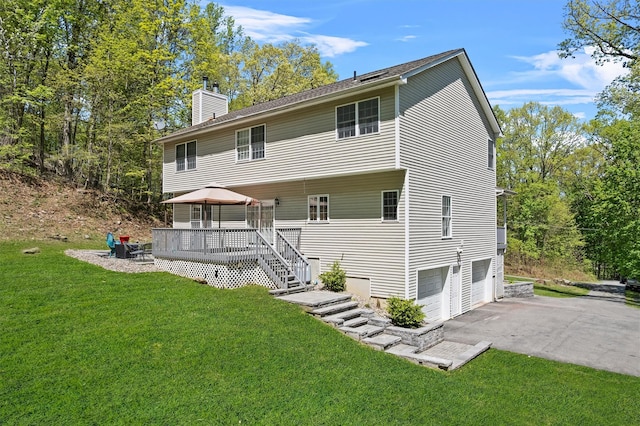 back of property featuring a gazebo, a yard, an attached garage, and a chimney