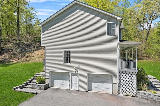 view of home's exterior featuring a garage, a yard, and driveway