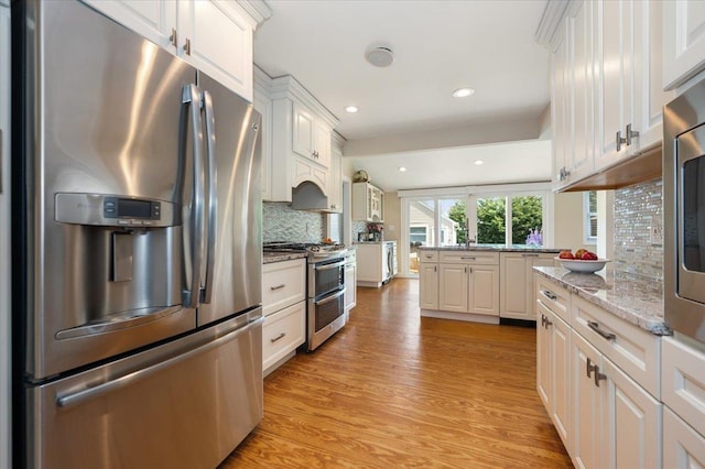 kitchen featuring light wood-style floors, stainless steel appliances, recessed lighting, white cabinetry, and tasteful backsplash