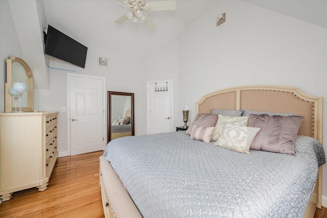 bedroom featuring ceiling fan, visible vents, light wood-type flooring, high vaulted ceiling, and baseboards