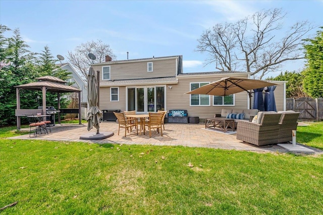 rear view of property featuring fence, a gazebo, an outdoor hangout area, a patio, and a yard