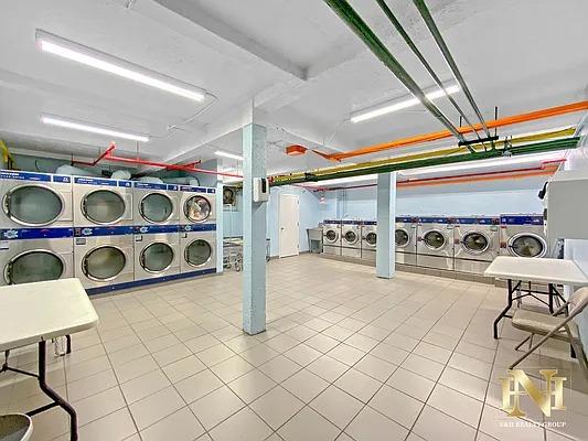 community laundry room with stacked washing maching and dryer, washing machine and dryer, and tile patterned flooring