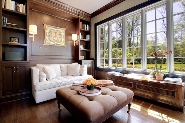 living area with built in features, crown molding, and dark wood-style flooring