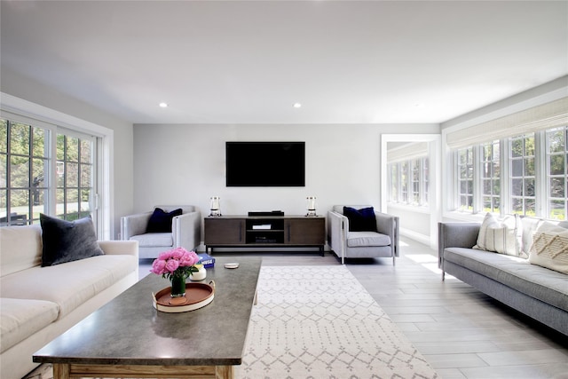 living room featuring plenty of natural light, recessed lighting, wood finished floors, and baseboards