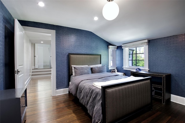 bedroom featuring lofted ceiling, dark wood-type flooring, baseboards, wallpapered walls, and recessed lighting