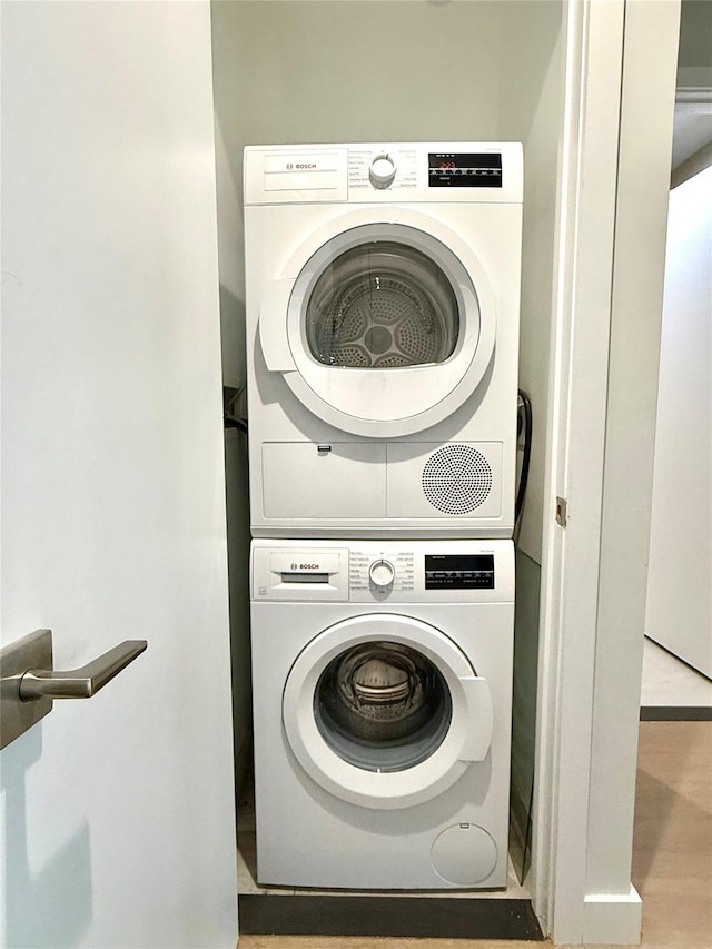 14-33 31st Ave Unit 4H, Astoria, NY 11106 - washroom with laundry area, stacked washer and dryer, and wood finished floors