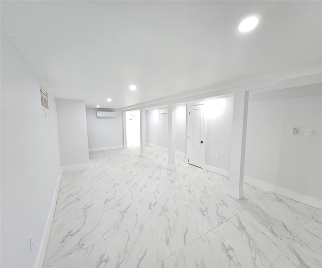 finished basement featuring baseboards, a wall mounted AC, recessed lighting, and marble finish floor