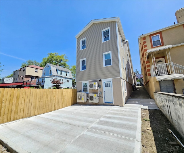 rear view of house with fence, ac unit, and a residential view