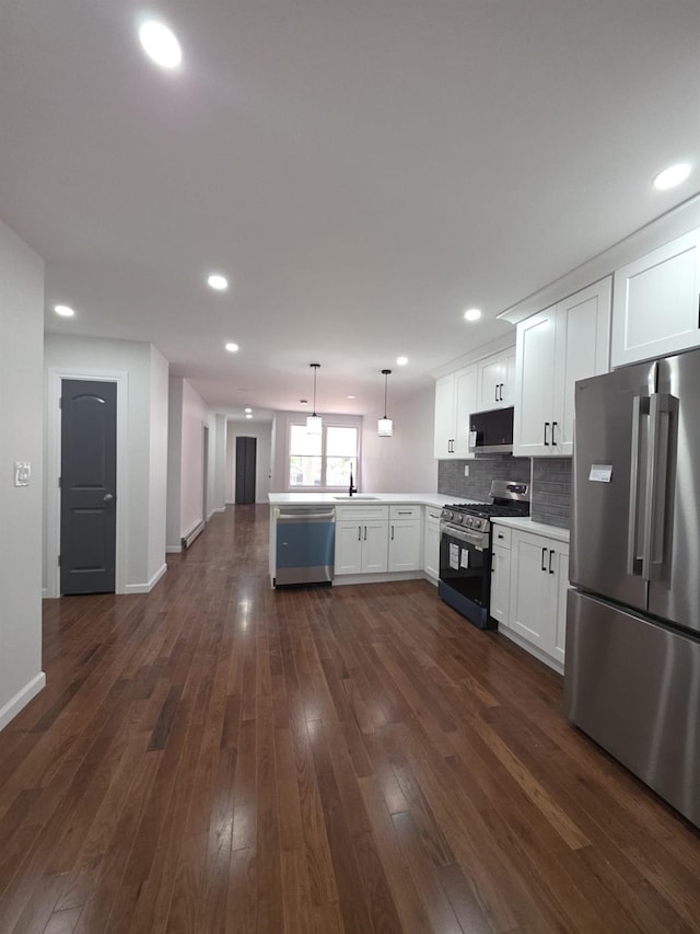 217 E 86th St, Brooklyn, NY 11236 - kitchen with stainless steel appliances, a peninsula, open floor plan, a sink, and white cabinetry