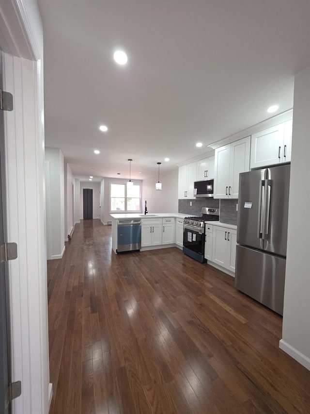 217 E 86th St, Brooklyn, NY 11236 - kitchen with stainless steel appliances, a peninsula, dark wood finished floors, tasteful backsplash, and white cabinets