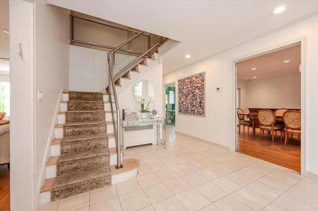 staircase featuring recessed lighting, tile patterned floors, baseboards, and radiator heating unit