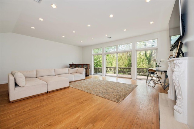 living room featuring light wood-style floors, vaulted ceiling, and recessed lighting