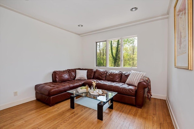living room featuring ornamental molding, baseboards, recessed lighting, and light wood-style floors